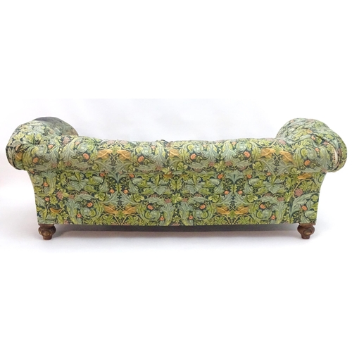 2092 - A Victorian oak framed Chesterfield settee, with scrolled and carved arms above floral detailing and... 