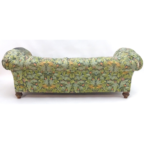 2092 - A Victorian oak framed Chesterfield settee, with scrolled and carved arms above floral detailing and... 