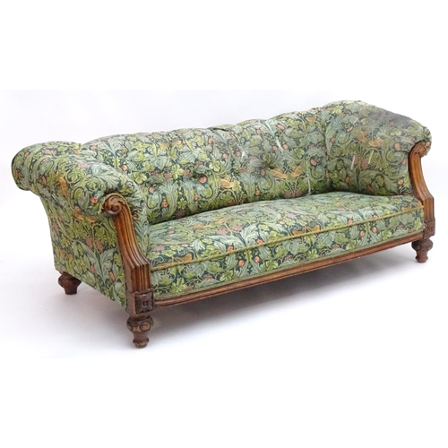 2092 - A Victorian oak framed Chesterfield settee, with scrolled and carved arms above floral detailing and... 