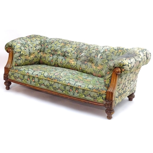 2092 - A Victorian oak framed Chesterfield settee, with scrolled and carved arms above floral detailing and... 