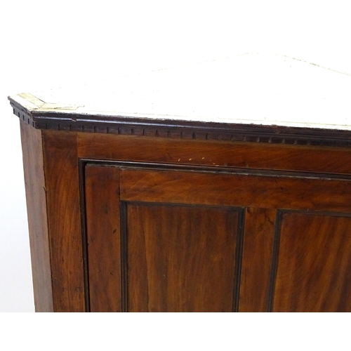 2095 - A late 18thC mahogany corner cupboard with a moulded cornice above a four panelled door and cast met... 