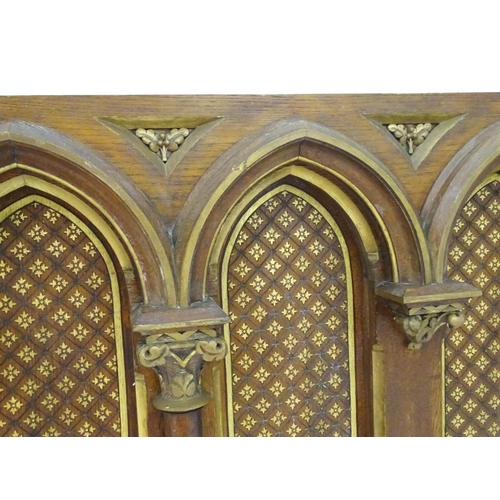 2105 - An ecclesiastical Gothic panel with columns, moulded arches, gilt painted decoration and floral moti... 