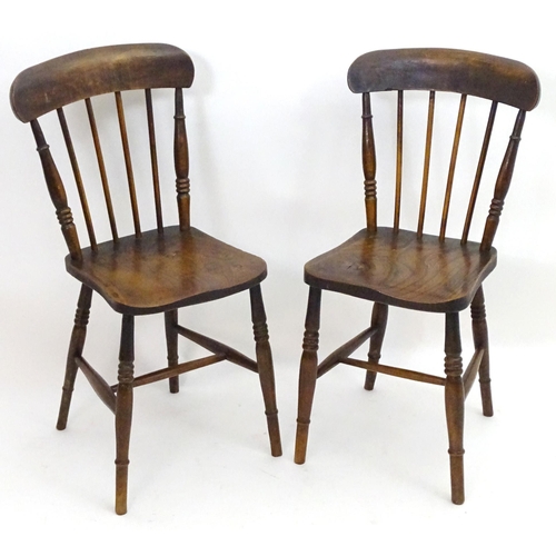 2106 - A pair of late 19thC Windsor chairs with shaped top rails and spindle backs above elm seats and turn... 