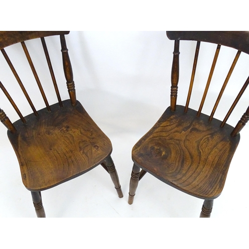 2106 - A pair of late 19thC Windsor chairs with shaped top rails and spindle backs above elm seats and turn... 