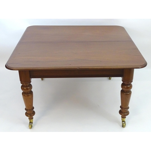 2113 - A late 19thC mahogany dining table with a moulded top above four large turned tapering legs terminat... 