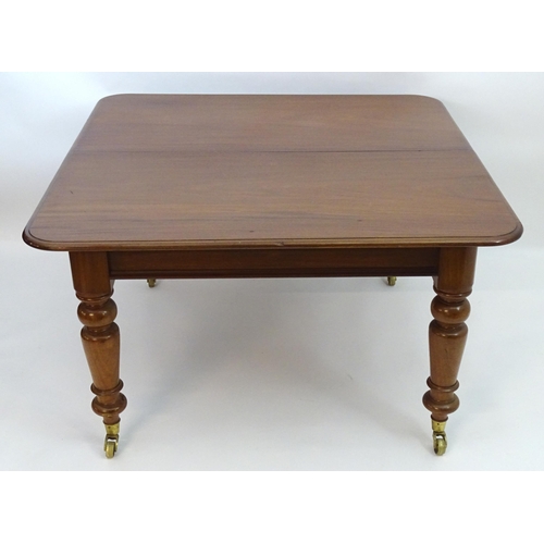 2113 - A late 19thC mahogany dining table with a moulded top above four large turned tapering legs terminat... 