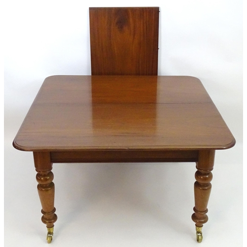 2113 - A late 19thC mahogany dining table with a moulded top above four large turned tapering legs terminat... 