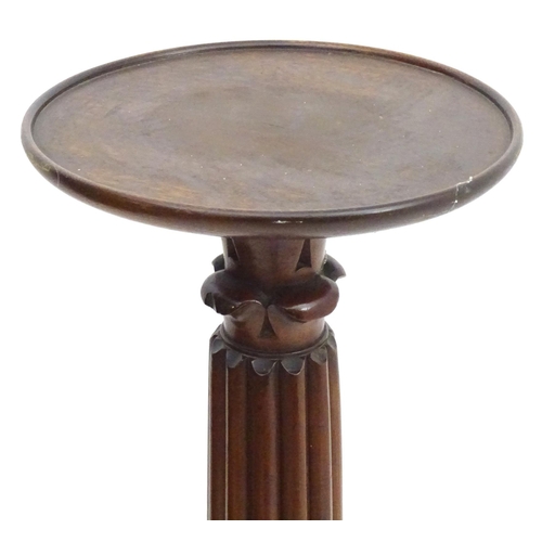 2117 - A late 19thC / early 20thC mahogany torchiere with a dished top above a reeded and carved stem with ... 