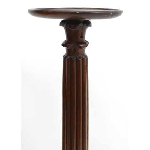 2117 - A late 19thC / early 20thC mahogany torchiere with a dished top above a reeded and carved stem with ... 