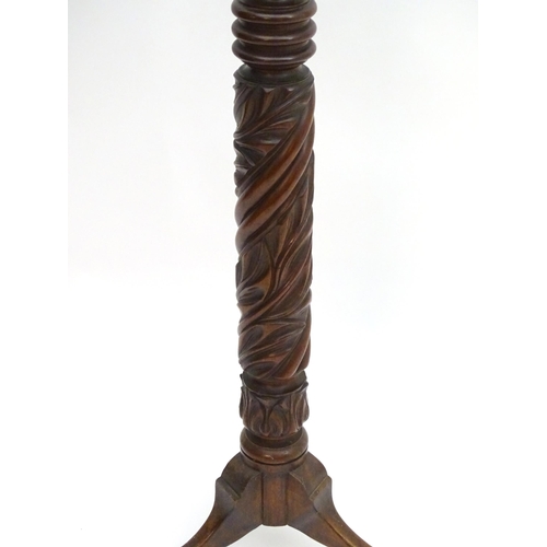 2117 - A late 19thC / early 20thC mahogany torchiere with a dished top above a reeded and carved stem with ... 