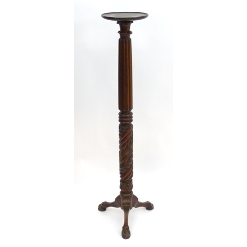 2117 - A late 19thC / early 20thC mahogany torchiere with a dished top above a reeded and carved stem with ... 