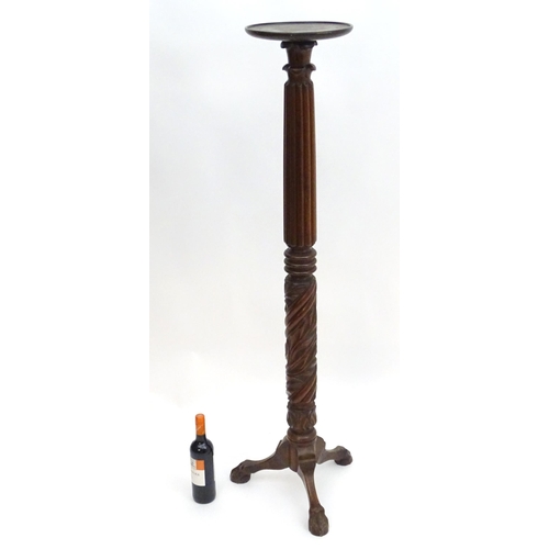 2117 - A late 19thC / early 20thC mahogany torchiere with a dished top above a reeded and carved stem with ... 