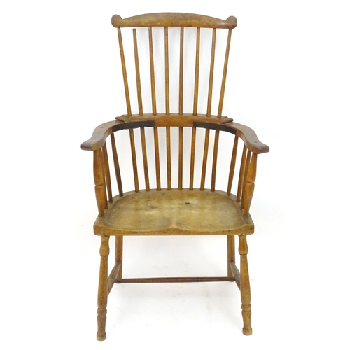 2118 - An early / mid 19thC comb back Windsor chair with a double bow back and saddle seat above turned tap... 