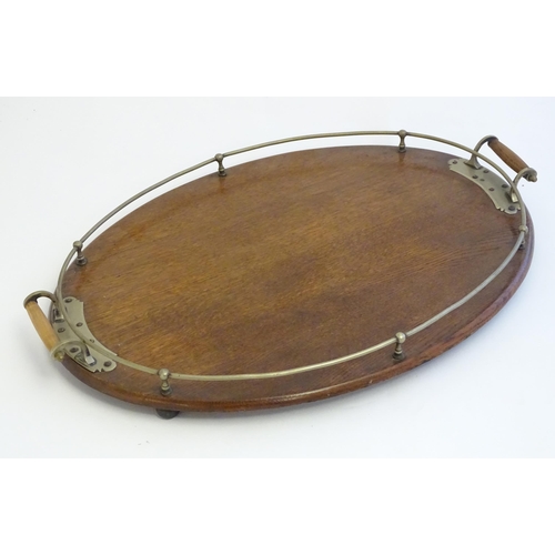 1355 - An early 20thC oak oval tray with twin handles and brass mounts and gallery. Approx. 15 3/4