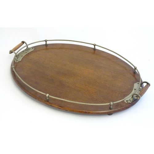 1355 - An early 20thC oak oval tray with twin handles and brass mounts and gallery. Approx. 15 3/4