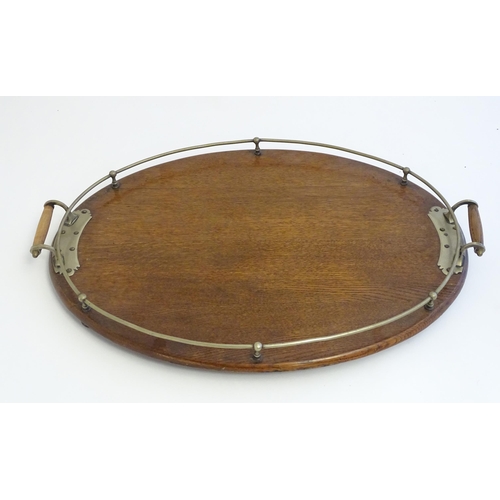 1355 - An early 20thC oak oval tray with twin handles and brass mounts and gallery. Approx. 15 3/4