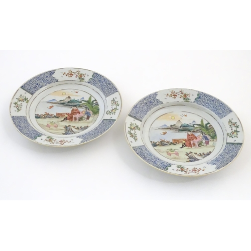 31A - A pair of Chinese plates depicting a two figures in a garden watching a bat, with sea and mountains ... 