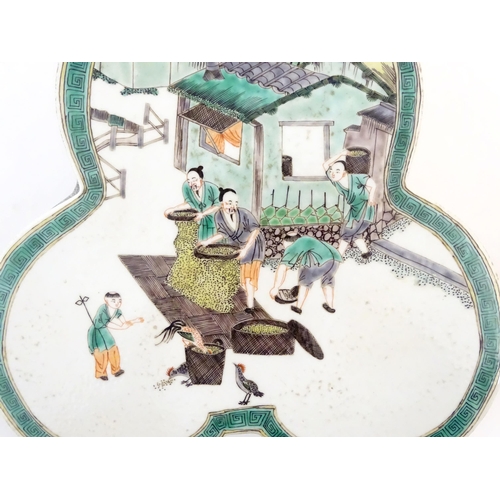 44 - A Chinese famille verte stand of trefoil form depicting figures sifting grain and shooing chickens. ... 