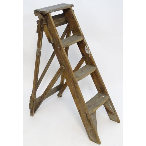 1584 - An early to mid 20thC wooden shop step ladder, latticed and folding, with metal plaque marked ' C A ... 