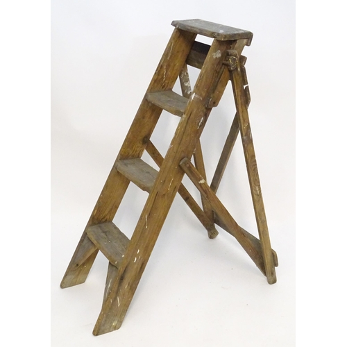 1584 - An early to mid 20thC wooden shop step ladder, latticed and folding, with metal plaque marked ' C A ... 