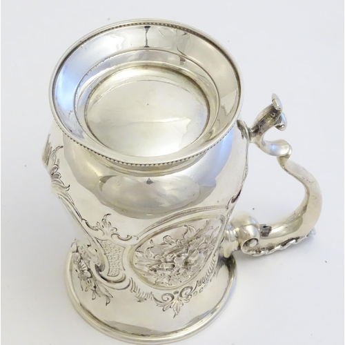 341 - A Victorian silver mug with embossed decoration and gilded interior. Hallmarked London 1864 maker Au... 