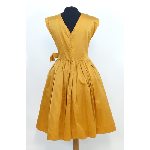 1547 - Vintage clothing / fashion: A c1950's dress in orange, with full skirt and tulle under, waist measur... 