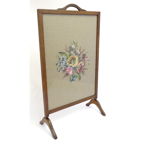 2110 - An early 20thC needlework fire screen with a mahogany frame and carrying handle to the top. 21