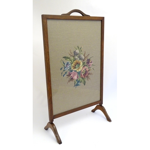 2110 - An early 20thC needlework fire screen with a mahogany frame and carrying handle to the top. 21