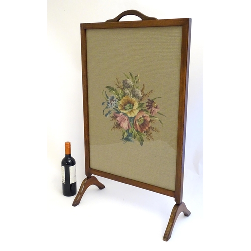 2110 - An early 20thC needlework fire screen with a mahogany frame and carrying handle to the top. 21