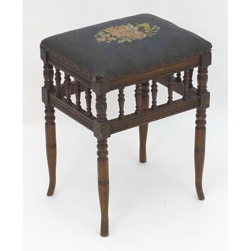 2112 - An Edwardian piano stool with floral needlework top with turned finial supports above four turned ta... 