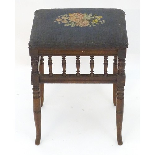 2112 - An Edwardian piano stool with floral needlework top with turned finial supports above four turned ta... 