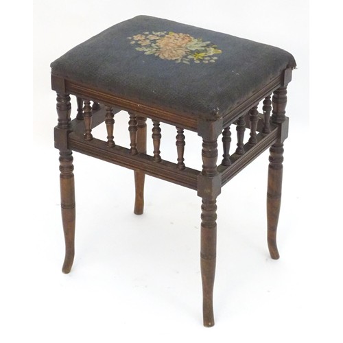 2112 - An Edwardian piano stool with floral needlework top with turned finial supports above four turned ta... 