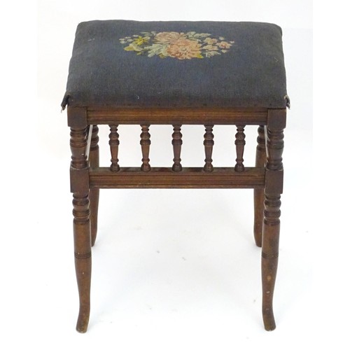 2112 - An Edwardian piano stool with floral needlework top with turned finial supports above four turned ta... 