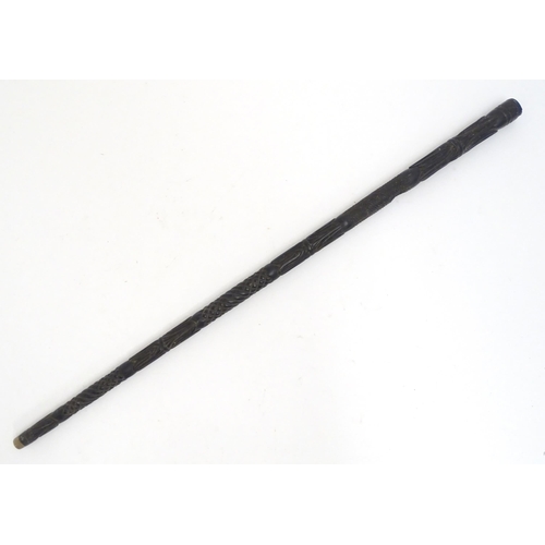 1468 - An Indian ebony walking cane / stick with carved detail. Approx. 32 1/2