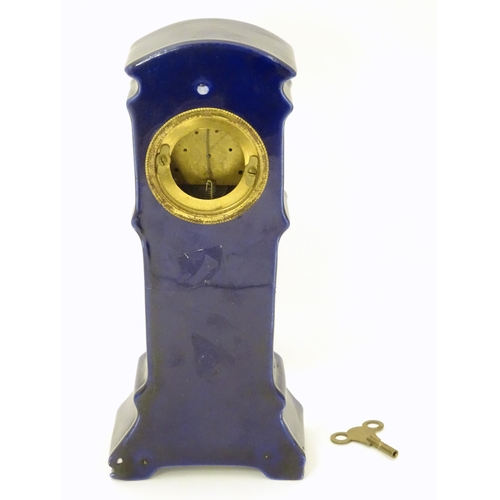 2286 - A Jugendstil mantle clock formed as a ceramic cased long case clock with blue and gilt detail. the d... 