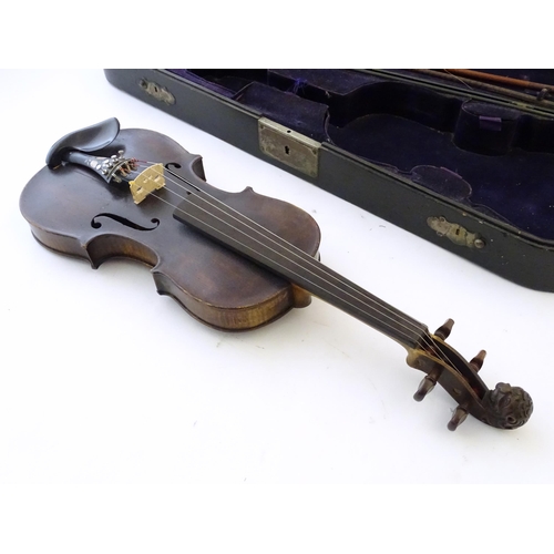 1540 - Musical Instruments: a 19thC German violin, of stained maple construction with carved lion's head sc... 