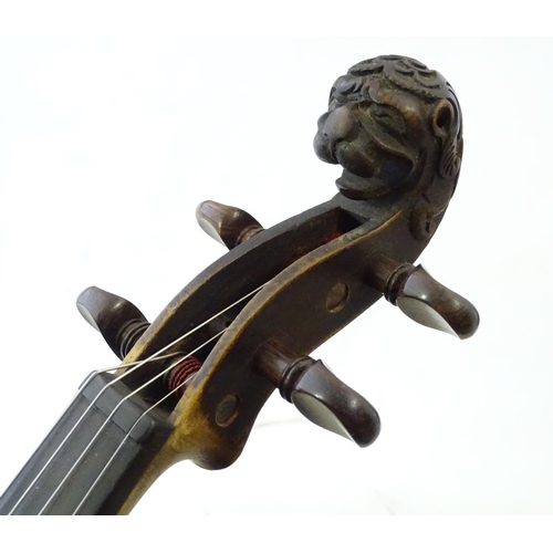 1540 - Musical Instruments: a 19thC German violin, of stained maple construction with carved lion's head sc... 