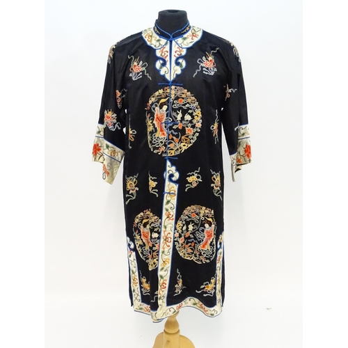 1548 - A Chinese informal coat, the black ground embroidered with Peking knot stitch decorative roundels de... 