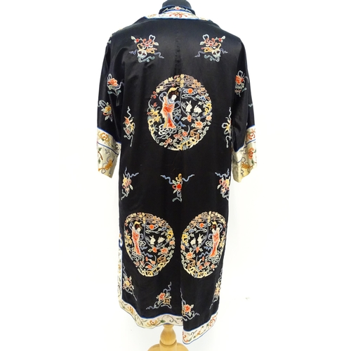 1548 - A Chinese informal coat, the black ground embroidered with Peking knot stitch decorative roundels de... 