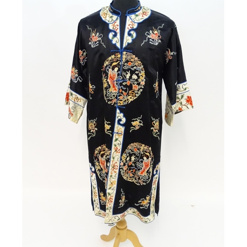 1548 - A Chinese informal coat, the black ground embroidered with Peking knot stitch decorative roundels de... 