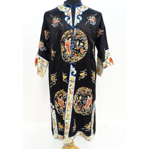 1548 - A Chinese informal coat, the black ground embroidered with Peking knot stitch decorative roundels de... 