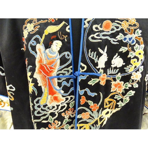 1548 - A Chinese informal coat, the black ground embroidered with Peking knot stitch decorative roundels de... 