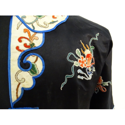 1548 - A Chinese informal coat, the black ground embroidered with Peking knot stitch decorative roundels de... 