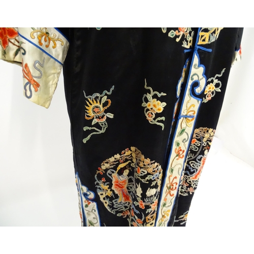 1548 - A Chinese informal coat, the black ground embroidered with Peking knot stitch decorative roundels de... 