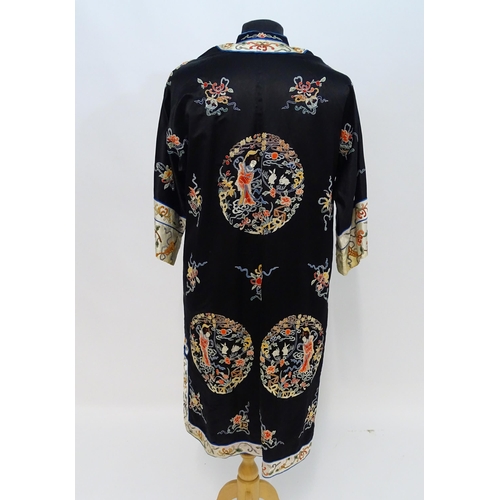 1548 - A Chinese informal coat, the black ground embroidered with Peking knot stitch decorative roundels de... 