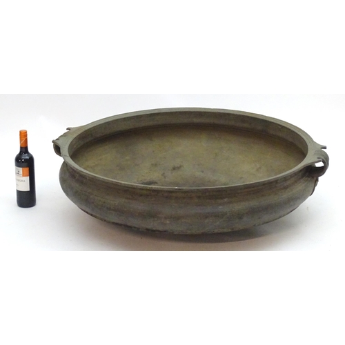 1352 - A 19thC large bronze basin / planter of circular form with twin handles and relief stylised heart de... 