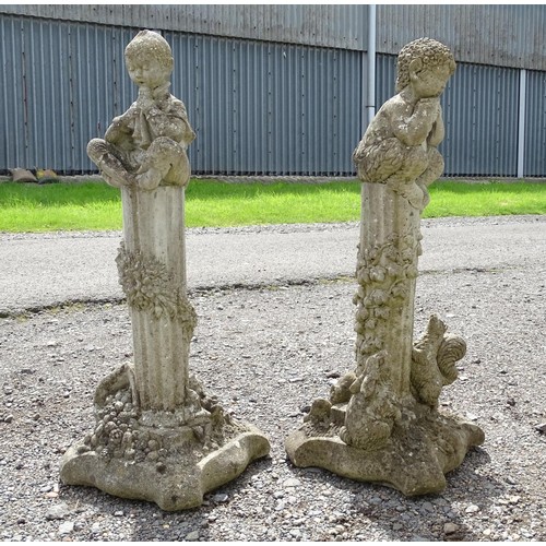 1370 - Garden & Architectural, Salvage: a pair of 20thC reconstituted stone statues formed as cherubs atop ... 