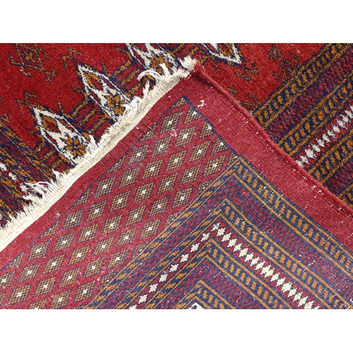 1383 - Carpet / Rug : A red ground rung with three bands of geometric motifs to centre bordered by further ... 