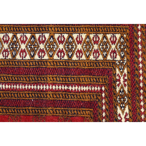 1383 - Carpet / Rug : A red ground rung with three bands of geometric motifs to centre bordered by further ... 