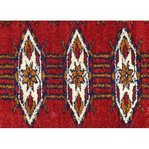 1383 - Carpet / Rug : A red ground rung with three bands of geometric motifs to centre bordered by further ... 